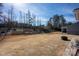 Expansive backyard with a fire pit, tiered garden beds, and fencing for privacy and outdoor enjoyment at 7672 Tanglewood Way, Denver, NC 28037