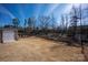 Large backyard featuring a storage shed, tiered garden beds, and secure fencing for versatile outdoor living at 7672 Tanglewood Way, Denver, NC 28037