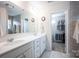 Modern bathroom with dual sinks, large mirror, and walk-in closet in view at 7672 Tanglewood Way, Denver, NC 28037