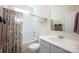Bright bathroom featuring a shower with floral curtain, white vanity, and a large mirror at 7672 Tanglewood Way, Denver, NC 28037