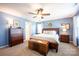 Comfortable bedroom with a wooden bed frame, chest, and ceiling fan at 7672 Tanglewood Way, Denver, NC 28037