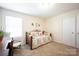 Spare bedroom featuring a daybed with a patterned cover, window, and desk at 7672 Tanglewood Way, Denver, NC 28037