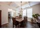 Elegant dining room showcasing coffered ceilings, oversized windows, hardwood floors and modern chandelier at 7672 Tanglewood Way, Denver, NC 28037