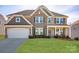 Beautiful two-story home featuring stone accents, attached garage, landscaped front yard and a welcoming front porch at 7672 Tanglewood Way, Denver, NC 28037
