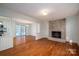 Open living space with hardwood floors, fireplace, and access to the kitchen and sunroom at 8080 Monbo Rd, Catawba, NC 28609