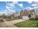 Two-story brick home with a well-manicured lawn, two-car garage, and a long driveway, located on a corner lot at 8603 Ridgeline Ln, Charlotte, NC 28269