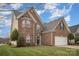 Attractive two-story brick home with a two-car garage, arched windows, and a lush, green landscaped front yard at 8603 Ridgeline Ln, Charlotte, NC 28269