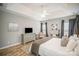 Comfortable bedroom with a tray ceiling, neutral walls, wood flooring, and a decorative art collection at 8603 Ridgeline Ln, Charlotte, NC 28269