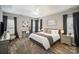 Comfortable bedroom with a tray ceiling, neutral walls, wood flooring, and a decorative art collection at 8603 Ridgeline Ln, Charlotte, NC 28269