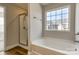 Bathroom featuring shower and soaking tub with a large window overlooking the surrounding nature at 8822 Crape Myrtle Dr, Stanfield, NC 28163