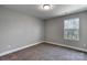 Small bedroom with carpet flooring, and window overlooking the surrounding natural setting at 8822 Crape Myrtle Dr, Stanfield, NC 28163