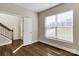 Bright bedroom with hardwood floors, a window with blinds, and a view into the hallway and stairway at 8822 Crape Myrtle Dr, Stanfield, NC 28163