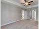 Carpeted bedroom with tray ceilings, ceiling fan, closet and doorway to the hallway at 8822 Crape Myrtle Dr, Stanfield, NC 28163