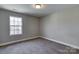 Empty bedroom featuring neutral walls, carpet floors, window overlooking trees and natural light at 8822 Crape Myrtle Dr, Stanfield, NC 28163