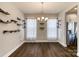 Dining area with dark floors, modern light fixture, display shelving, and stainless steel refrigerator at 8822 Crape Myrtle Dr, Stanfield, NC 28163