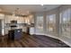Bright kitchen with gray backsplash, white cabinets, granite counters, stainless appliances and dark island at 8822 Crape Myrtle Dr, Stanfield, NC 28163