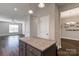 Modern kitchen island with granite top, view to the living room, and updated fixtures and appliances at 8822 Crape Myrtle Dr, Stanfield, NC 28163