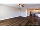 Open-concept living room with hardwood floors, ceiling fan, and view to kitchen with island at 8822 Crape Myrtle Dr, Stanfield, NC 28163