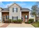 Charming two-story townhouse with brick and siding exterior, landscaped front yard, and inviting entrance at 8830 Cinnabay Dr, Charlotte, NC 28216