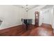 Spacious room with hardwood floors, a piano, grandfather clock, and a view of the home's entrance at 8830 Cinnabay Dr, Charlotte, NC 28216