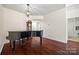 Open living room with hardwood floors and a black grand piano at 8830 Cinnabay Dr, Charlotte, NC 28216