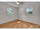 Bright bedroom featuring hardwood floors, two windows, and neutral paint at 908 Dogwood Dr, Gastonia, NC 28054