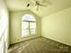 Comfortable bedroom featuring a large, arched window and ceiling fan at 9513 Isaac Hunter Dr, Charlotte, NC 28214
