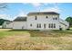 Large backyard features a spacious lawn and a rear view of the white home at 9900 Meadowmead Ct, Charlotte, NC 28273