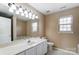 Bathroom with white cabinets, large mirror, vanity lighting, and a window at 9900 Meadowmead Ct, Charlotte, NC 28273