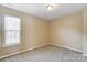 Carpeted bedroom with a large window with blinds and neutral paint at 9900 Meadowmead Ct, Charlotte, NC 28273