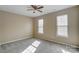 Neutral bedroom featuring cozy carpet, ceiling fan and two bright windows at 9900 Meadowmead Ct, Charlotte, NC 28273