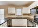 Functional kitchen featuring white cabinets, black countertops, and modern appliances at 9900 Meadowmead Ct, Charlotte, NC 28273
