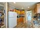 Well-lit kitchen with appliances, wood cabinets, and adjacent laundry area at 1049 Ramsey St, Stanley, NC 28164