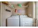 Functional laundry room featuring washer, dryer, and built-in shelving for ample storage at 1049 Ramsey St, Stanley, NC 28164