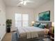 Cozy bedroom with a queen-sized bed, two windows, ceiling fan, and a plant at 1116 Crooked River Dr, Waxhaw, NC 28173