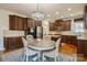 A spacious kitchen featuring dark cabinetry, an island, and a breakfast nook with a hanging light fixture at 1116 Crooked River Dr, Waxhaw, NC 28173