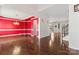 Formal dining room showcases rich wood floors, bright red walls, and elegant chandelier lighting at 1189 Sandy Bottom Nw Dr, Concord, NC 28027