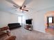 Cozy bonus room features neutral carpet, a ceiling fan, a futon, and TV for relaxation and entertainment at 1232 Scotch Meadows Loop, Monroe, NC 28110