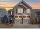 Beautiful two-story home featuring two-car garage, stone accents, and charming architectural details, creating curb appeal at 1232 Scotch Meadows Loop, Monroe, NC 28110