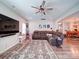 Spacious living room with a large sectional sofa, ceiling fan, large TV, and access to the dining area at 1232 Scotch Meadows Loop, Monroe, NC 28110