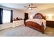 Comfortable main bedroom with neutral carpet, a ceiling fan, a large window, and a stylish wooden bed at 1232 Scotch Meadows Loop, Monroe, NC 28110