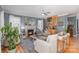 Cozy living room with a fireplace, hardwood floors, ceiling fan, and natural light at 12441 Morning Creek Ln, Charlotte, NC 28214