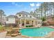 Luxurious backyard featuring a large pool, covered patio, and meticulously landscaped surroundings at 133 Crooked Branch Way, Troutman, NC 28166