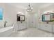 Bright bathroom featuring double sinks, a soaking tub, a modern chandelier, and luxurious tile flooring at 133 Crooked Branch Way, Troutman, NC 28166