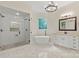 A luxurious bathroom featuring a glass shower, tub, double sink vanity, and marble floors at 133 Crooked Branch Way, Troutman, NC 28166