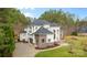 An exterior elevation of a large stucco and brick home with manicured lawn at 133 Crooked Branch Way, Troutman, NC 28166