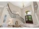 A grand foyer with a curved staircase, high ceilings, and decorative lighting at 133 Crooked Branch Way, Troutman, NC 28166