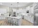 A bright, eat-in kitchen with white cabinets, stainless steel appliances, and a large center island at 133 Crooked Branch Way, Troutman, NC 28166