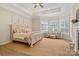 A serene main bedroom with tray ceilings, plantation shutters, sitting area, and a king bed at 133 Crooked Branch Way, Troutman, NC 28166