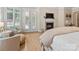 A well-lit main bedroom with a fireplace, seating area, and view of the backyard at 133 Crooked Branch Way, Troutman, NC 28166